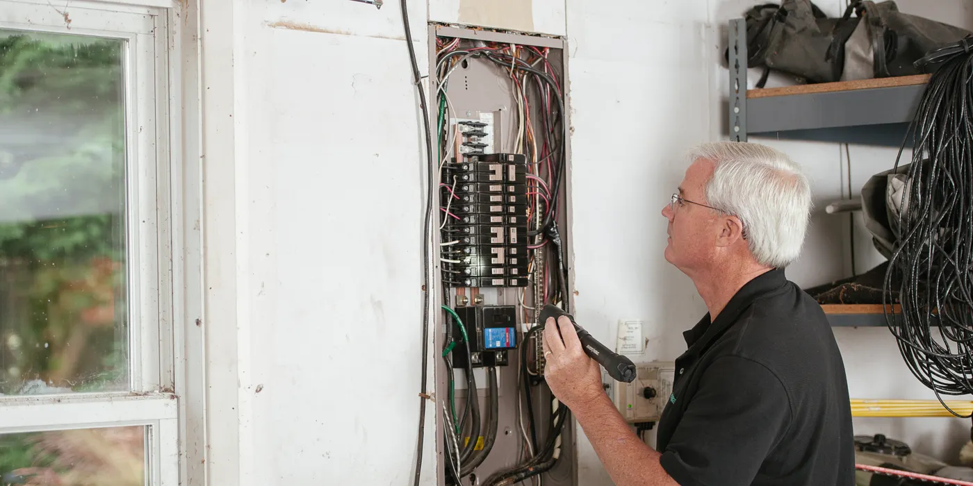 Electrician working inside an electrical distribution panel