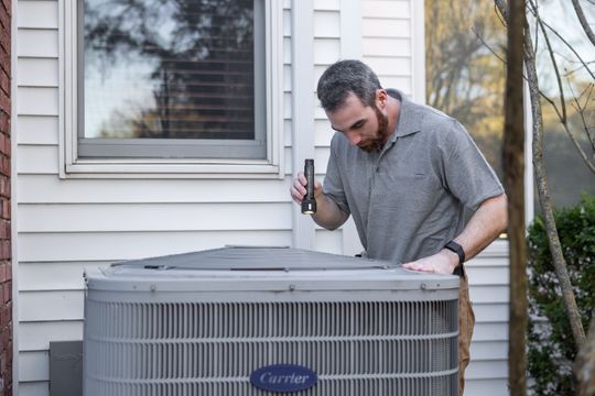 Técnico inspecionando unidade externa de climatização durante manutenção
