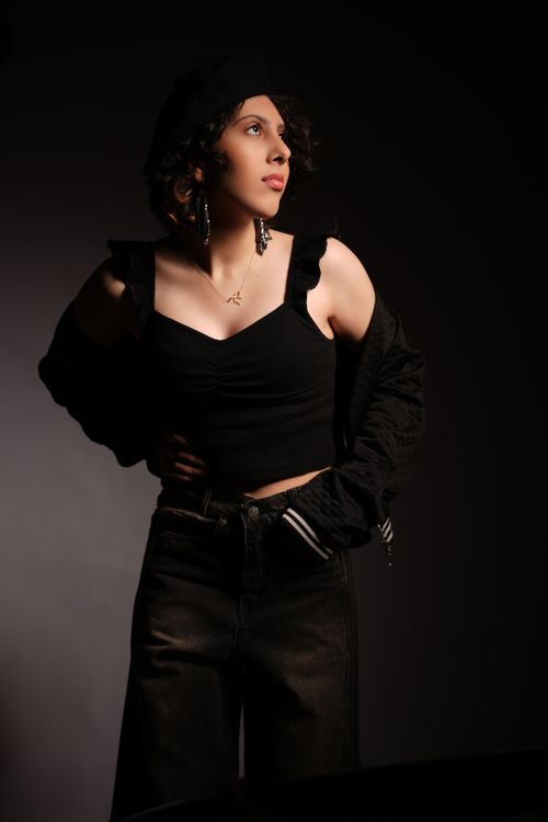 Free Stylish portrait of a woman in black clothing and beret with dramatic lighting. Stock Photo