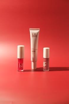 High-end skincare and makeup products elegantly displayed against a vibrant red backdrop.