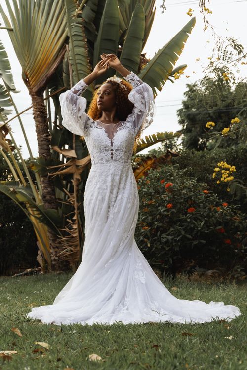 Free Beautiful bride in flowing white dress posing gracefully in a vibrant garden. Stock Photo