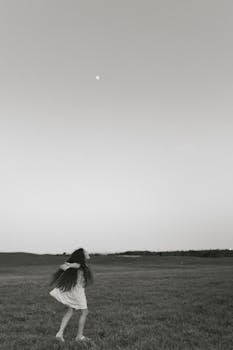 A child enjoys the vastness of an open field under the evening sky in West Palm Beach.