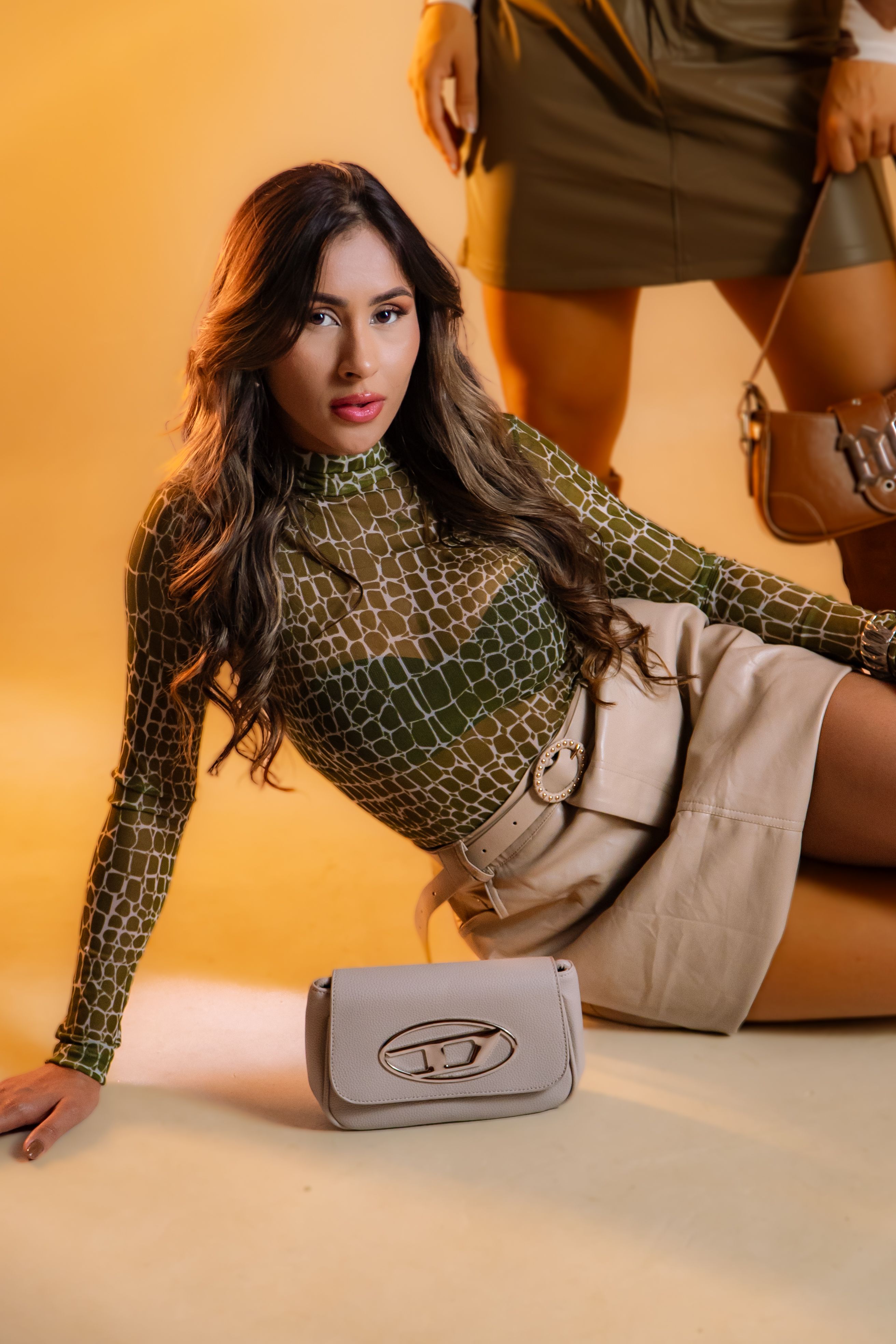Modelo posa com elegância em roupas e bolsa tendência contra um fundo suave.
