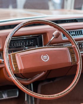 Close-up of a vintage car's interior featuring a classic steering wheel and dashboard.