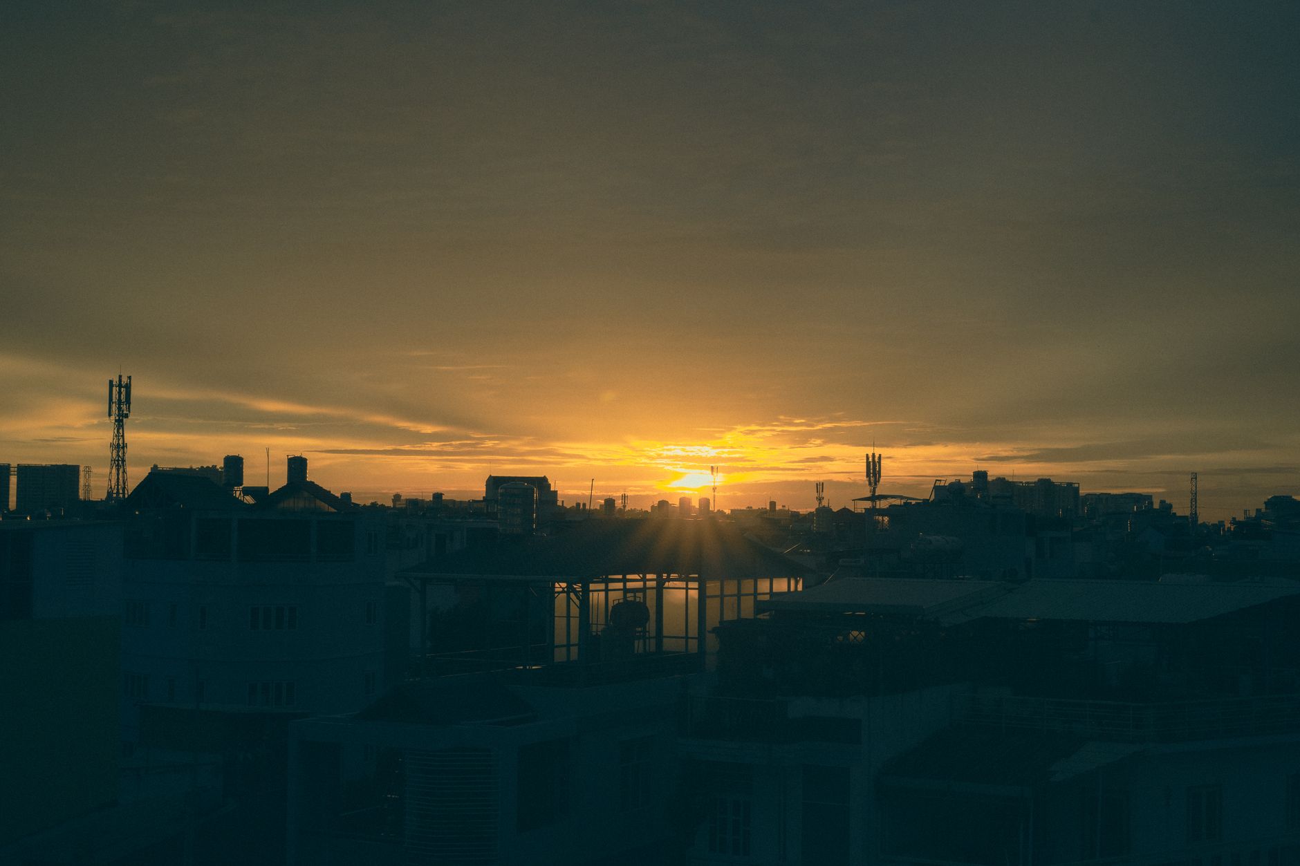 A stunning sunset over Ho Chi Minh City with urban skyline silhouettes and vibrant colors.