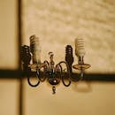 温暖的灯光下，一盏优雅的复古黄铜枝形吊灯投下阴影，灯上装有螺旋灯泡