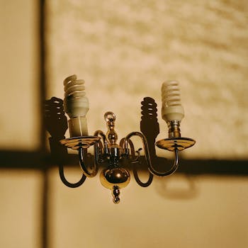 温暖的灯光下，一盏优雅的复古黄铜枝形吊灯投下阴影，灯上装有螺旋灯泡