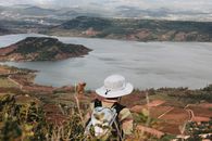 徒步旅行者戴着帽子，从上方俯瞰风景优美的湖泊和景观，享受宁静的户外体验