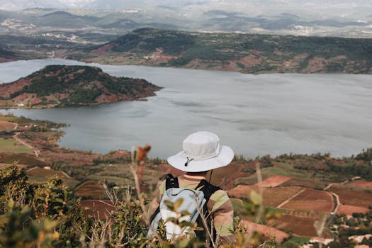 徒步旅行者戴着帽子，从上方俯瞰风景优美的湖泊和景观，享受宁静的户外体验