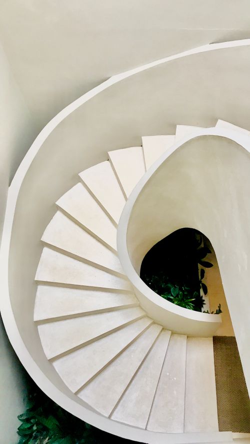Free Aerial view of a stunning white curved staircase in a luxury boutique hotel in Ubud, Bali. Stock Photo