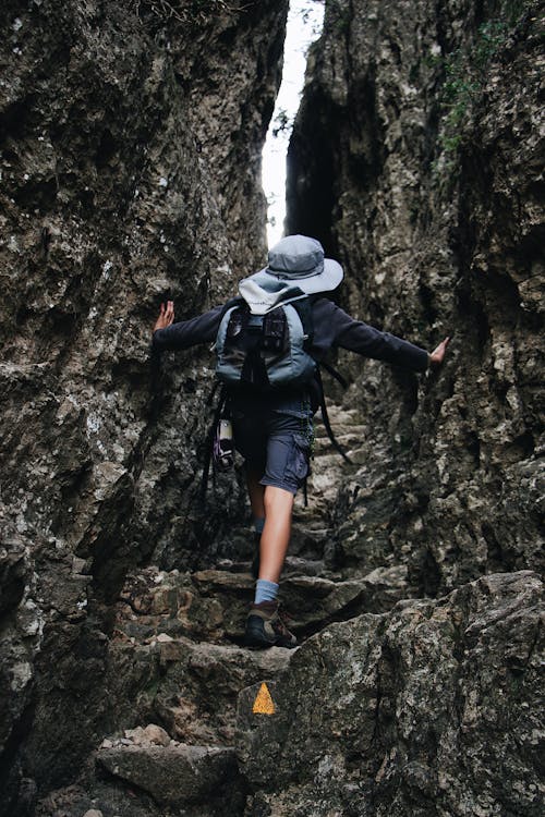 Person Carrying Back Pack Dan Hat Walking On Pathway