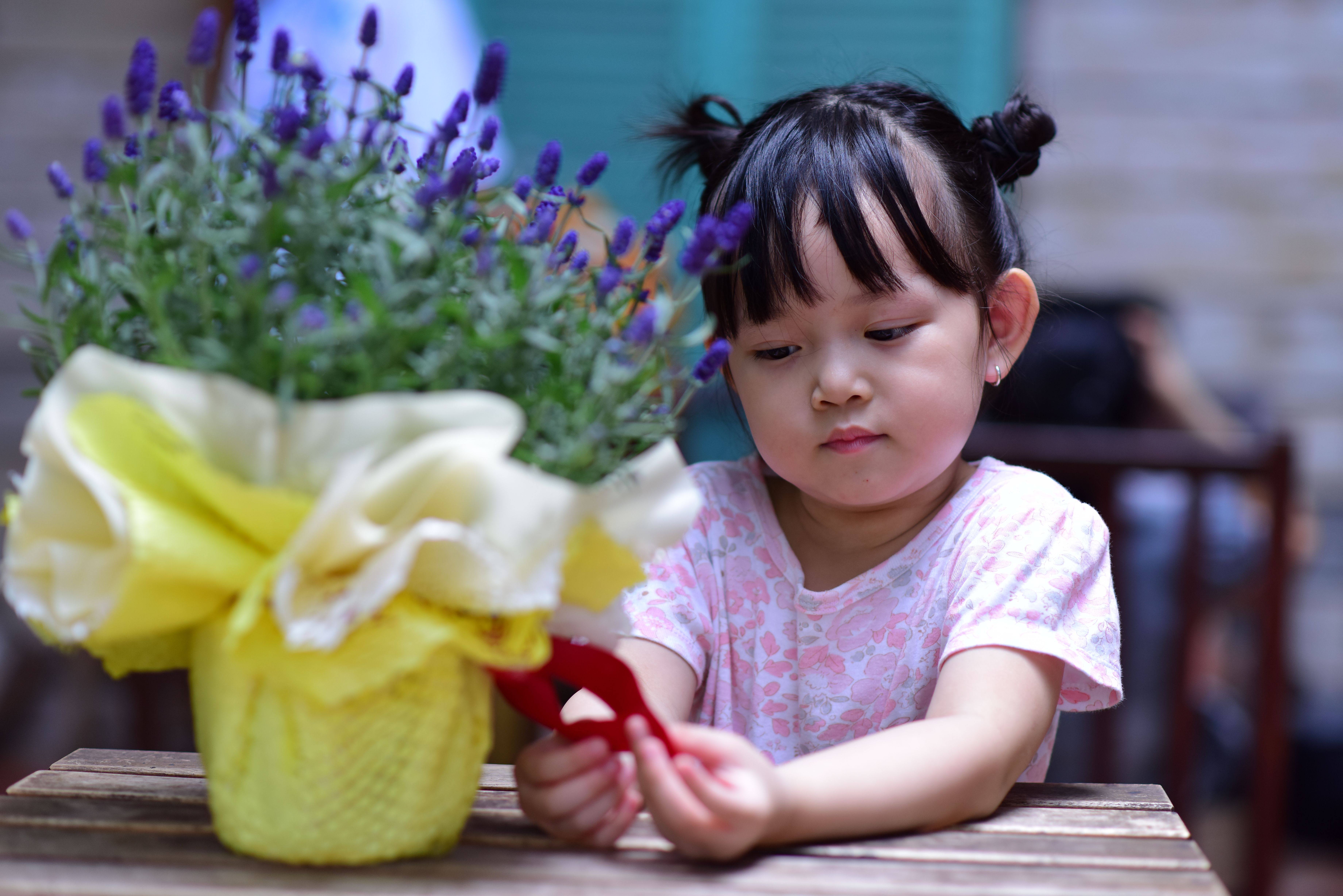 Young girl curiously examining a lavender bouquet indoors