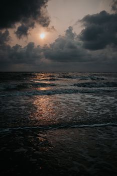 Captivating sunset over the North Sea at Sankt Peter-Ording, Germany with moody waves and a reflective shoreline.