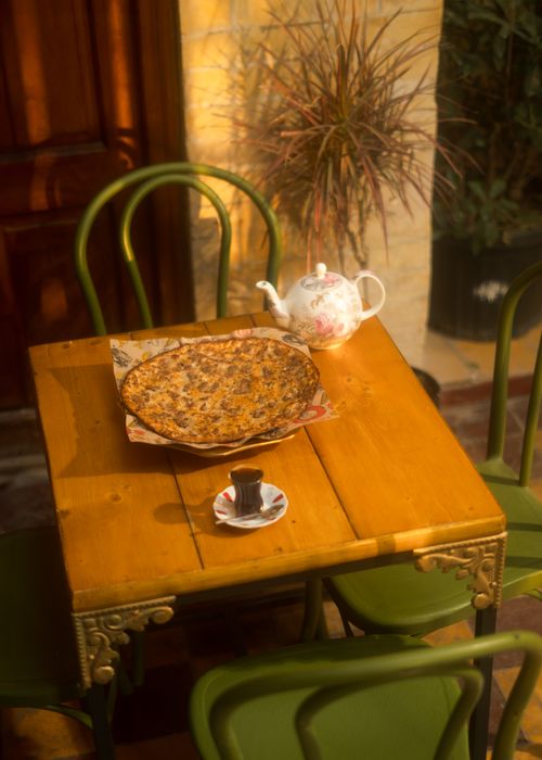 Free A serene outdoor setting in Baghdad showcasing traditional tea and a pastry on a wooden table. Stock Photo