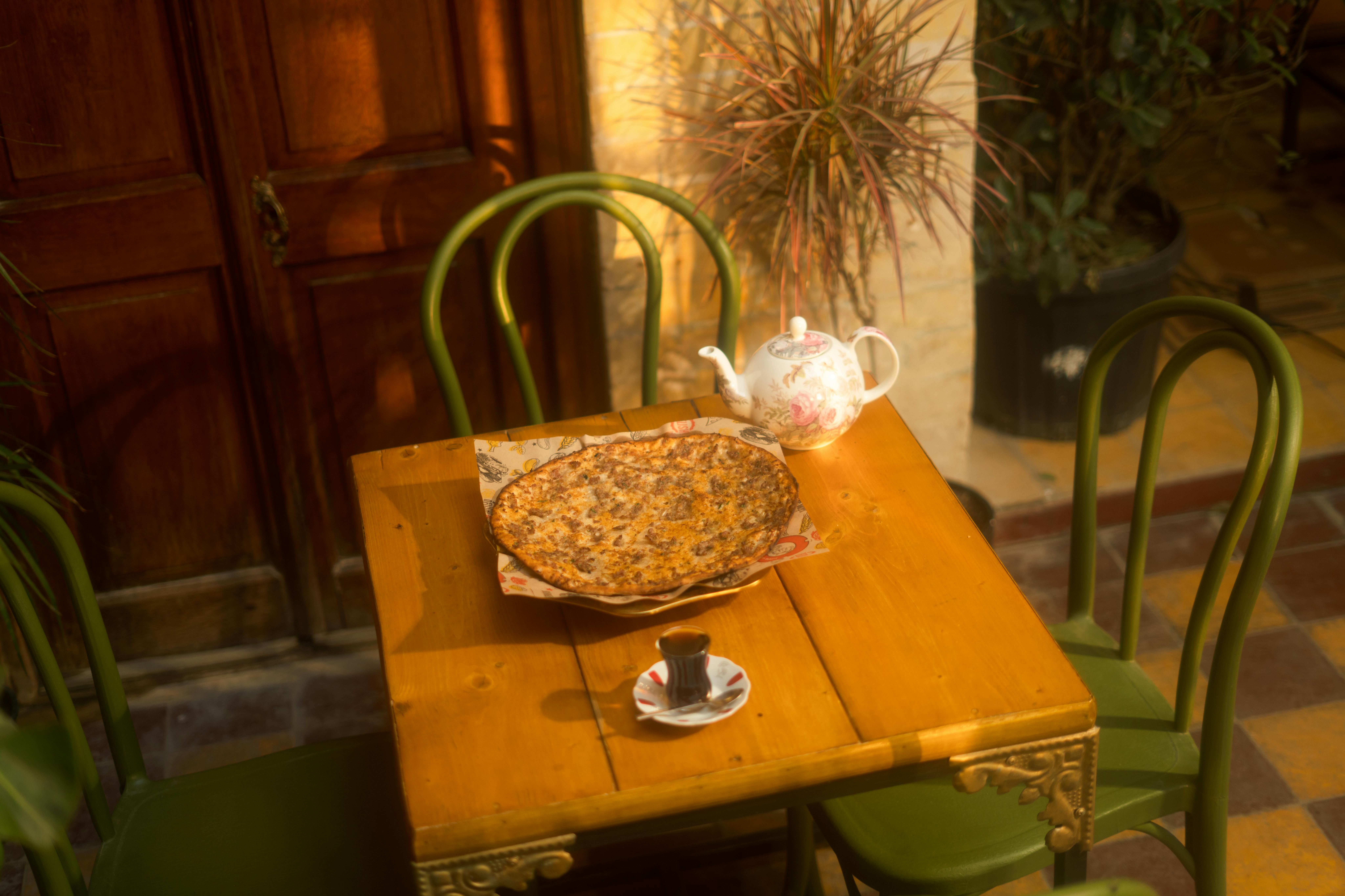 Gratis Tavolo rustico apparecchiato con piatti tradizionali iracheni e tè in un'accogliente atmosfera da cortile. Foto a disposizione