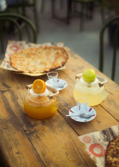 Free Glass teapots with citrus teas and fresh pizza on a rustic wooden table outdoors. Stock Photo