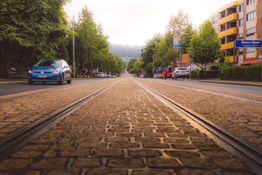 Low-angle view of a cobblestone street with tram tracks in Kassel, capturing sunset vibes.