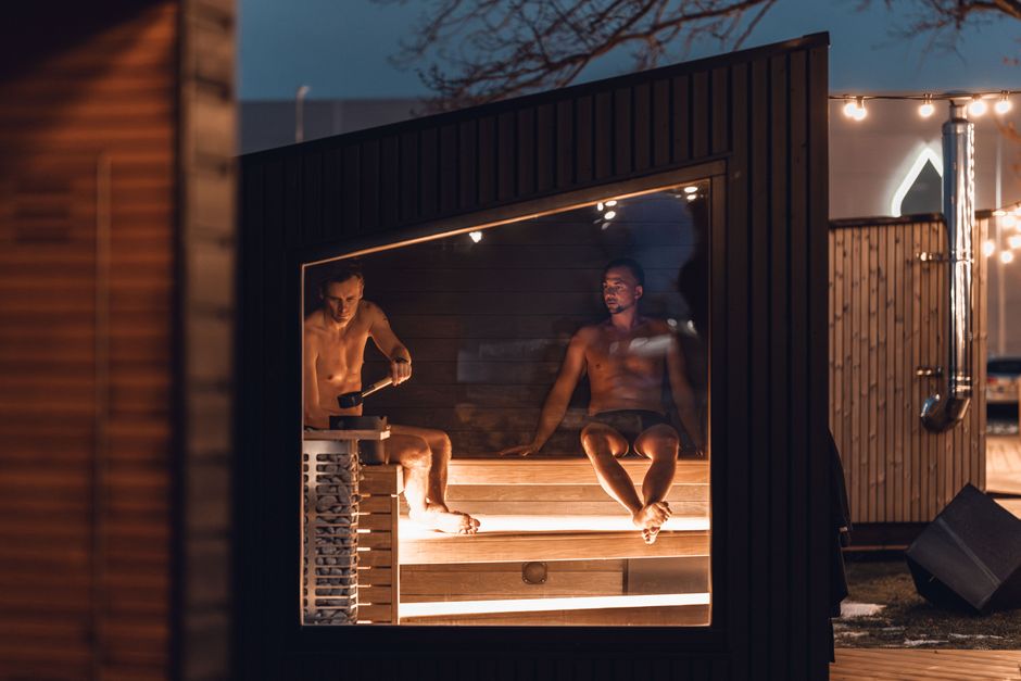 Cold Plunge Tubs: Benefits, Risks, and Best Options for Recovery Two men relax in a modern Nordic sauna cabin, enjoying a tranquil evening.