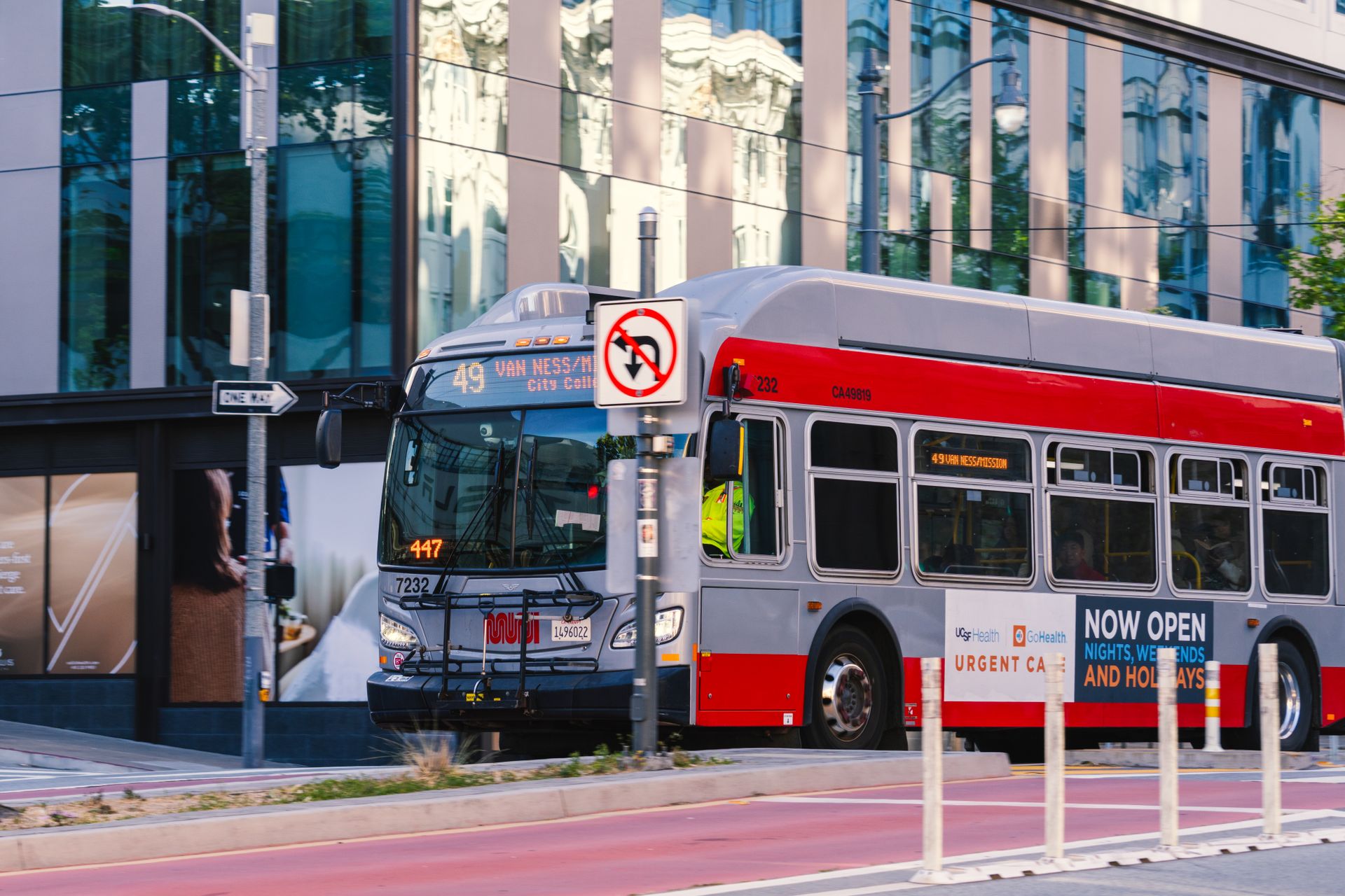 A San Francisco Muni bus traveling on Van Ness Avenue during the day in the cityscape.