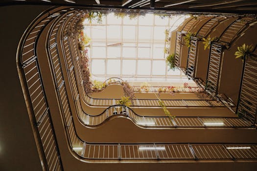 Upward view of a modern atrium with plants and natural light.