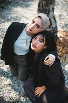 两名时尚女性在户外穿着时尚的服装，化着精致的妆容摆姿势