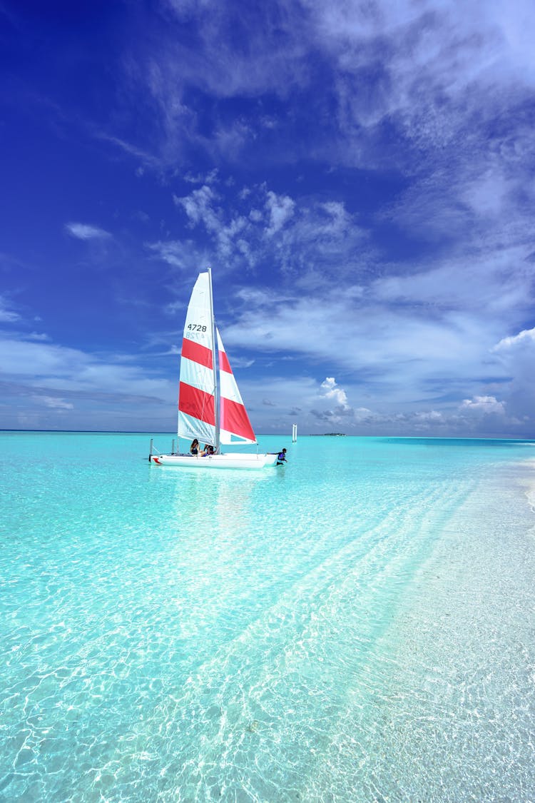 Red And White Watercraft On Body Of Water