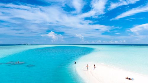 Free Turquoise waters and sandy beach in the Maldives during daylight with people relaxing and swimming. Stock Photo