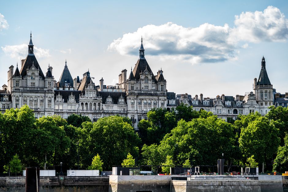 Iconic view of Whitehall's historic architecture and lush greenery in central London on a sunny day.