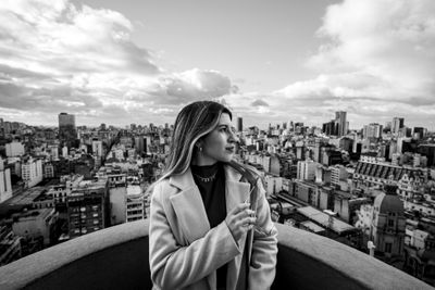 Mujer argentina joven sonriendo, retrato en blanco y negro con vista de Buenos Aires