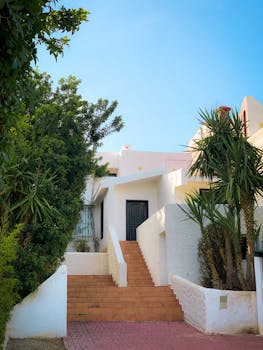 Stunning modern beach house exterior with lush greenery and blue sky backdrop.