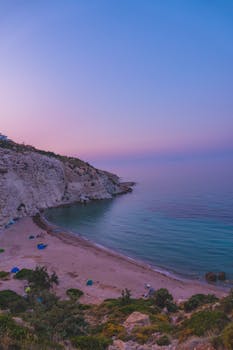 Beautiful pink sunrise over the tranquil coast of İzmir, Türkiye, with a serene beach view.