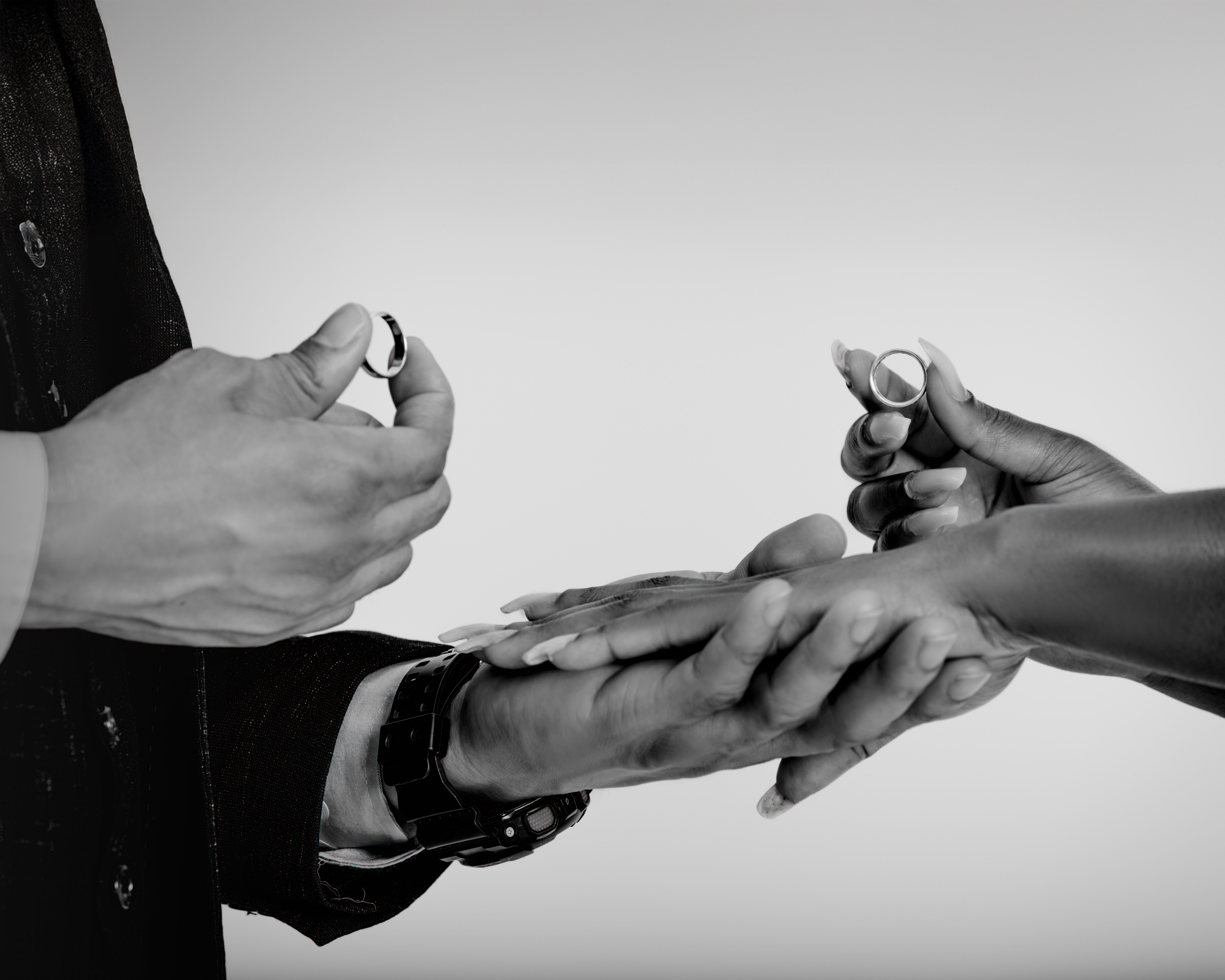 Close-up of hands exchanging wedding rings, symbolizing commitment and love.