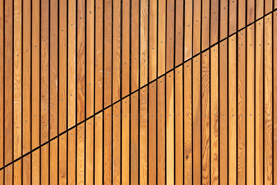 Detail einer montierten Holz-Lamellenwand mit sauberer Abschlussleiste und Schattenfuge