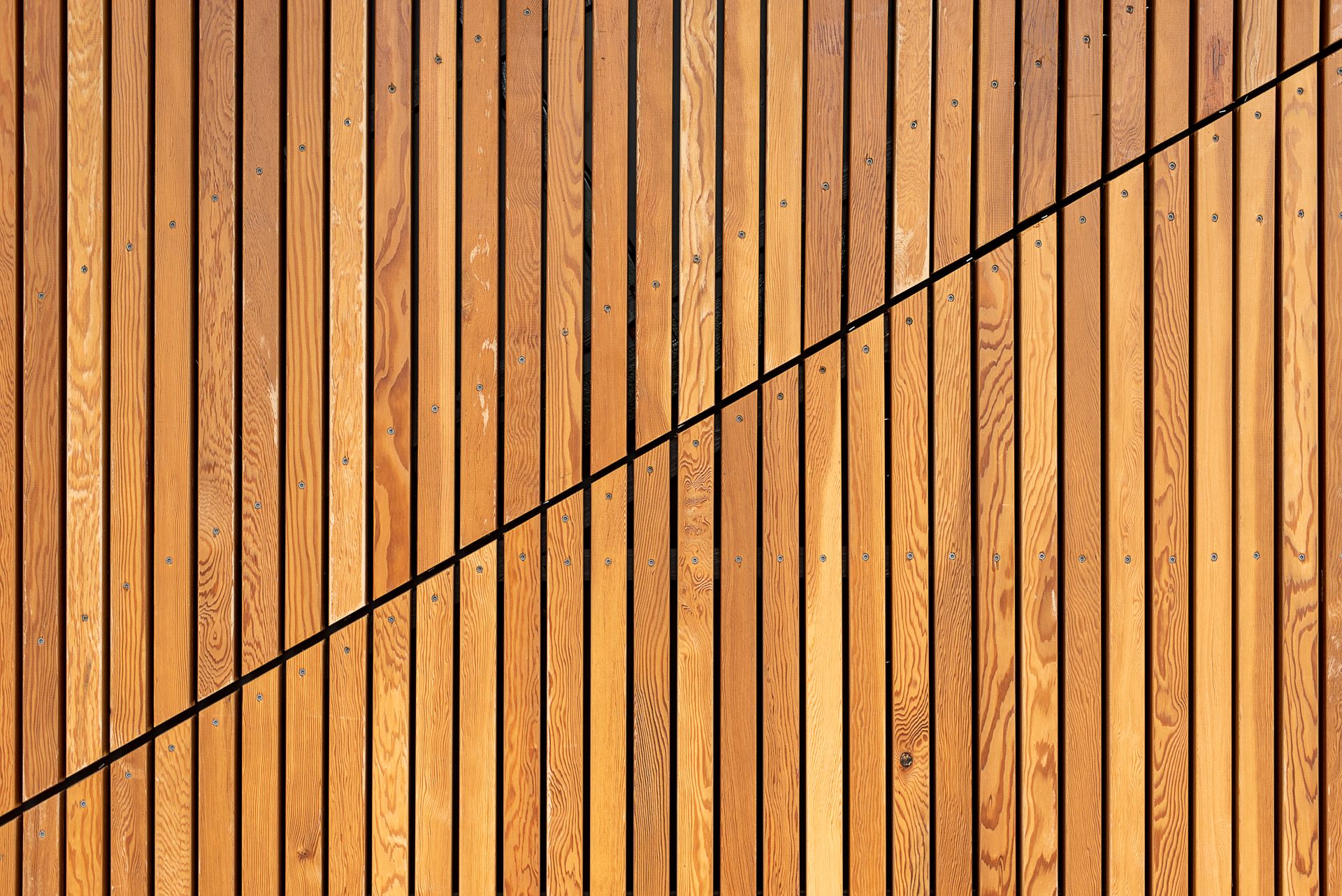 A close-up of wooden slats creating a modern diagonal pattern, ideal for backgrounds.