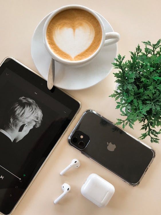 黑色iphone 11在airpods和咖啡杯旁边