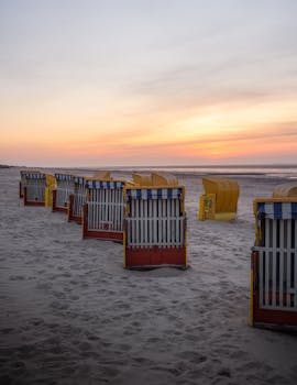Idyllic beach scene with colorful huts at sunset in Cuxhaven, Germany's Wadden Sea.
