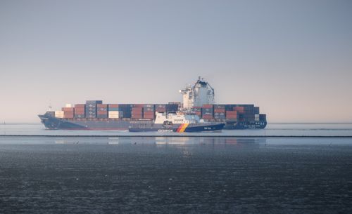 Free Serene view of a container ship near Cuxhaven, Germany. Perfect for maritime themes. Stock Photo