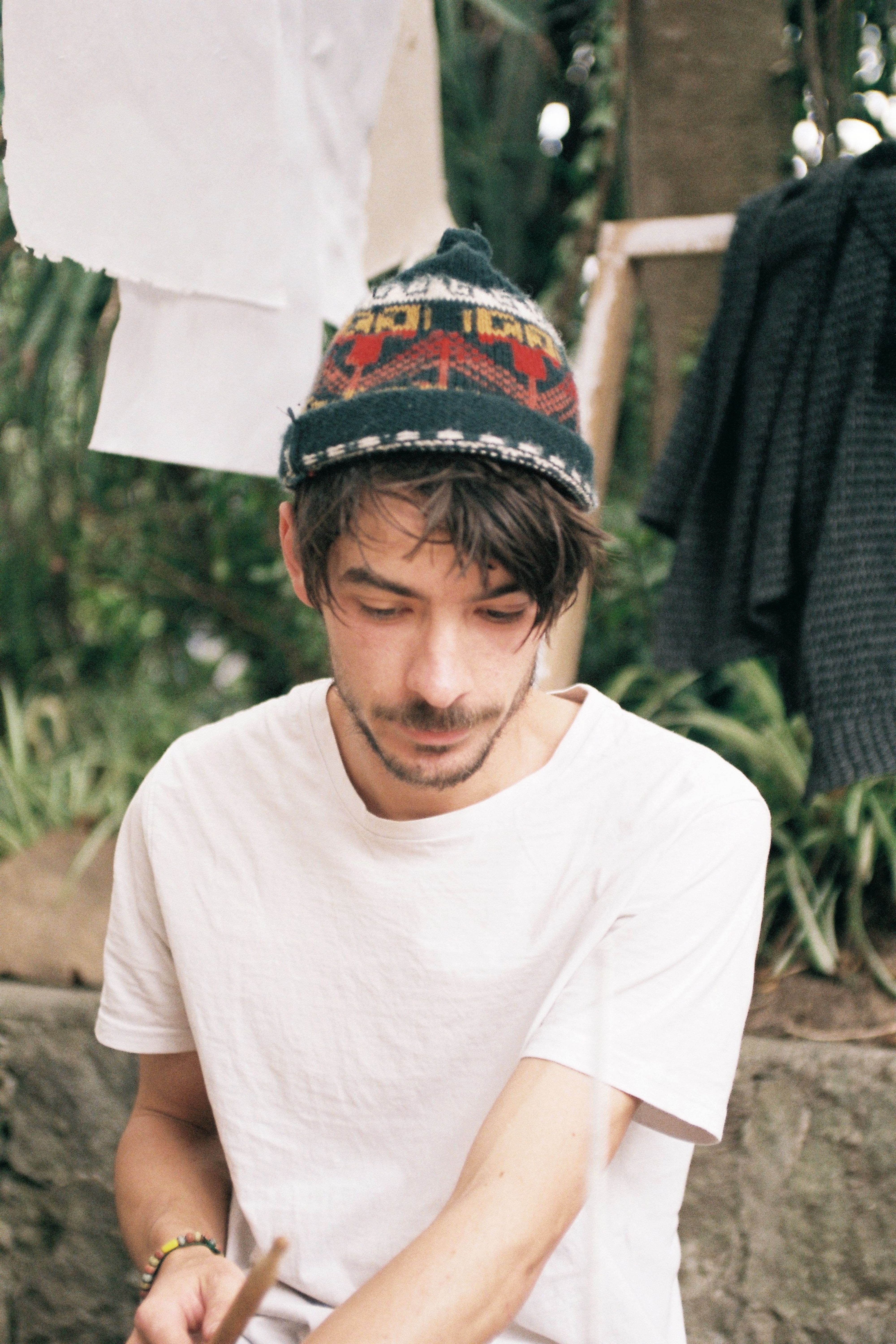 Street portrait of a man in colorful beanie and white shirt, Ecuador.