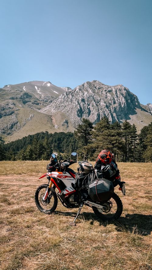 Free A motorbike parked in a stunning mountain vista on a sunny day. Stock Photo