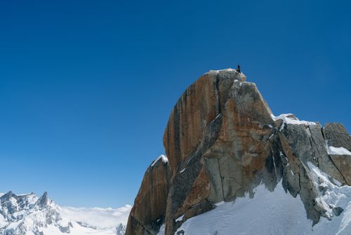 Free A lone climber stands atop a snowy peak in Chamonix-Mont-Blanc, France. Stock Photo