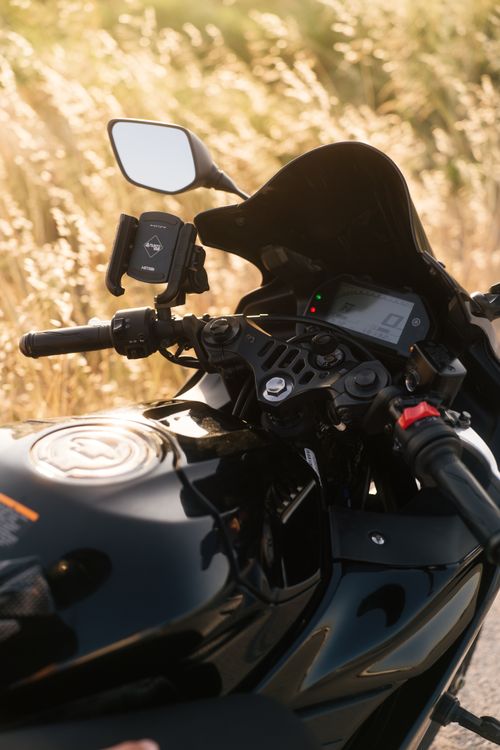 Free A close-up view of a motorcycle dashboard captured during sunny weather, highlighting the handlebars and mirrors. Stock Photo