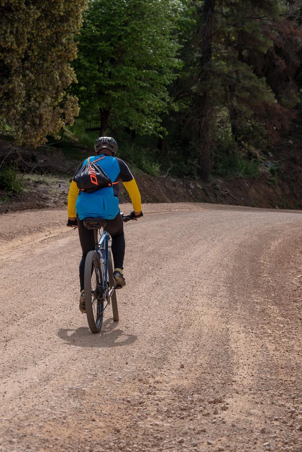 Cyclist on a gravel road by Taha Bensalmia on Pexels