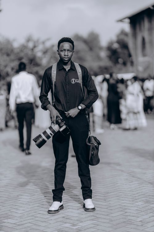 Free A professional photographer with camera gear standing outdoors at an event. Stock Photo