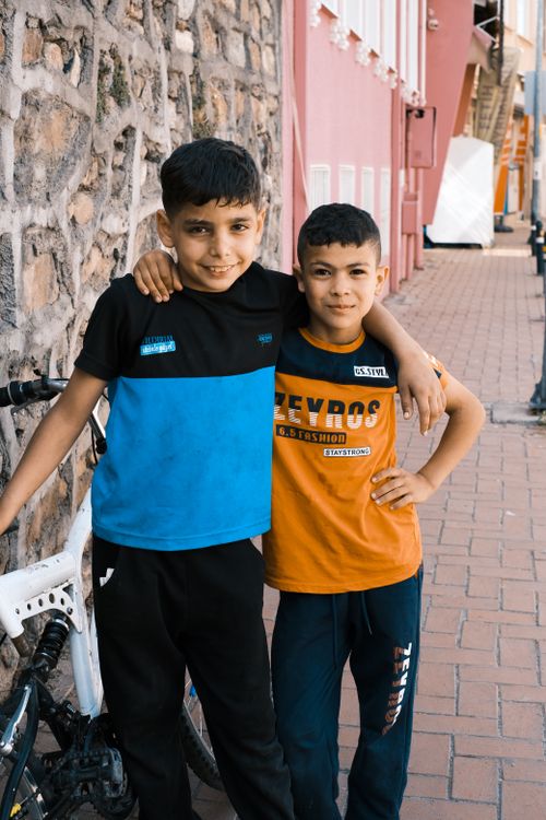 Free Two cheerful boys posing together next to a bike on a sunny day. Stock Photo