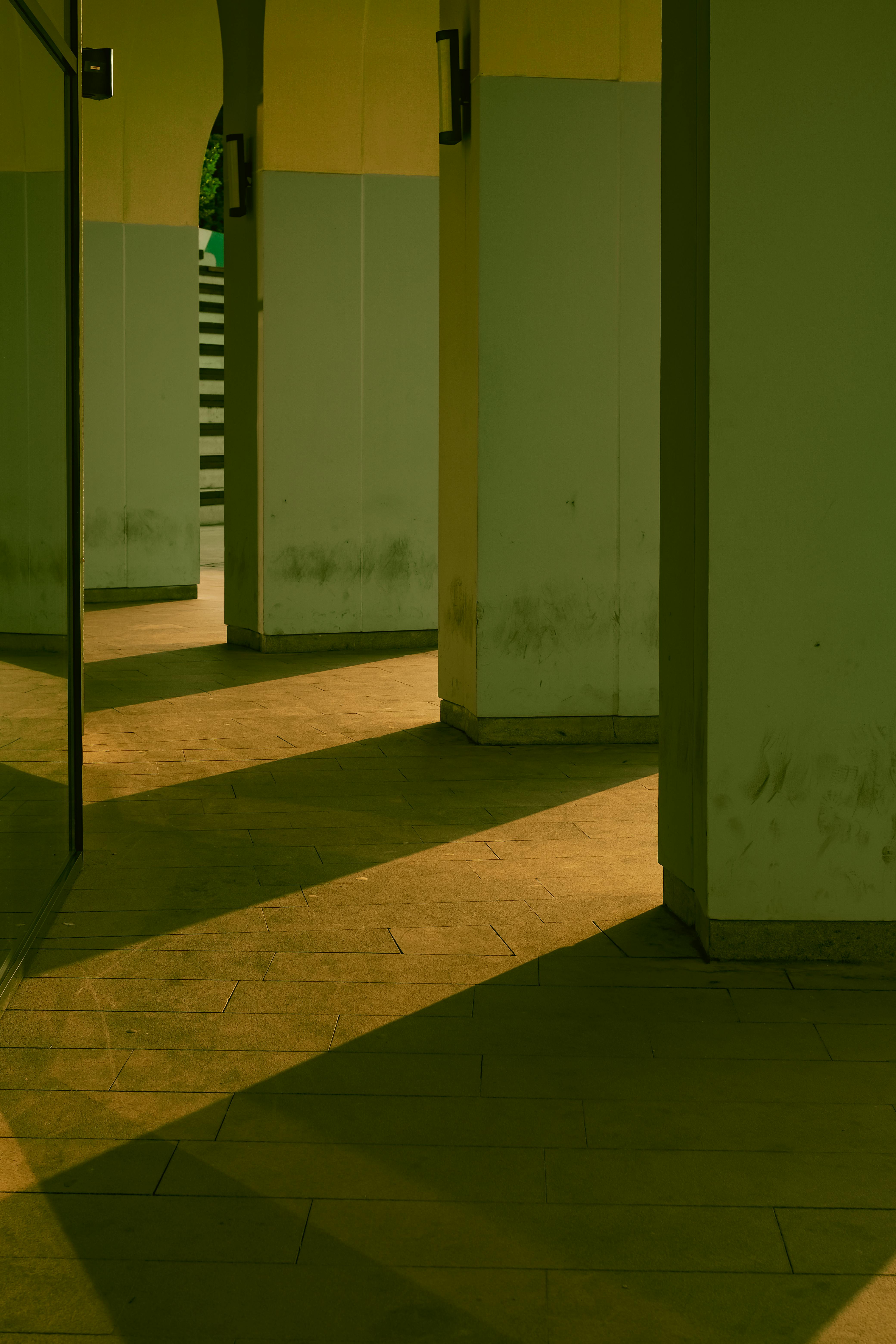 Gratis Et moderne arkitektonisk rum med slående skygger og geometriske former fremhævet af omgivende belysning. Lagerfoto