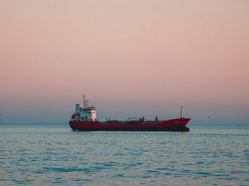 Free A red cargo ship sails under a pastel sky on Istanbul's tranquil waters at twilight. Stock Photo