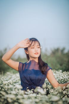 年轻女子优雅地在雏菊田里摆姿势，展现自然之美与时尚