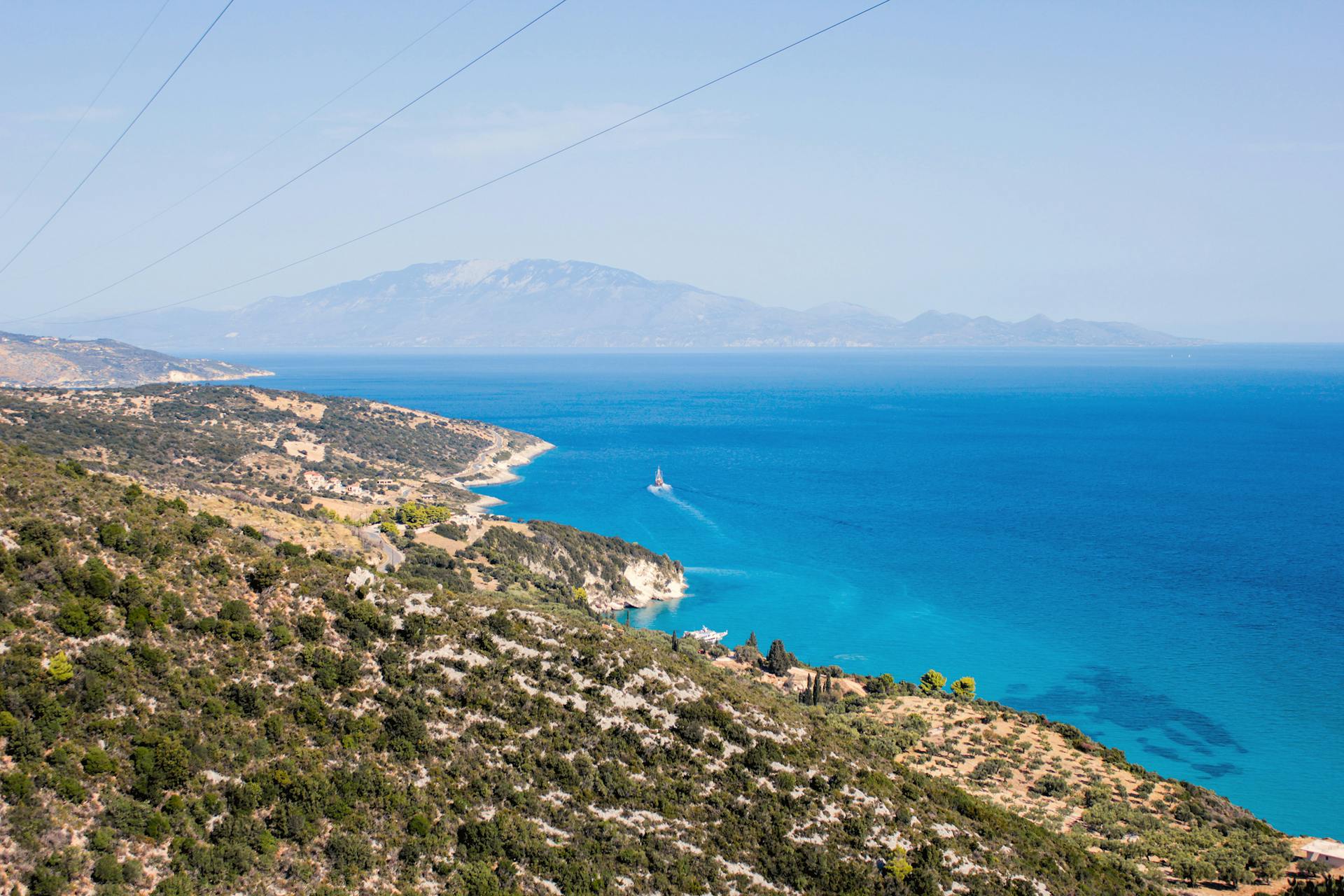 A stunning coastal landscape showcasing azure waters and rocky terrains under a clear blue sky.