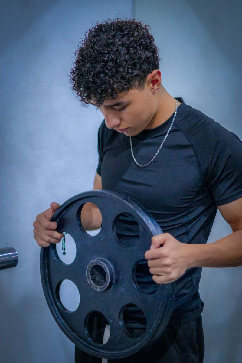 Athlete lifting a weight plate at the gym
