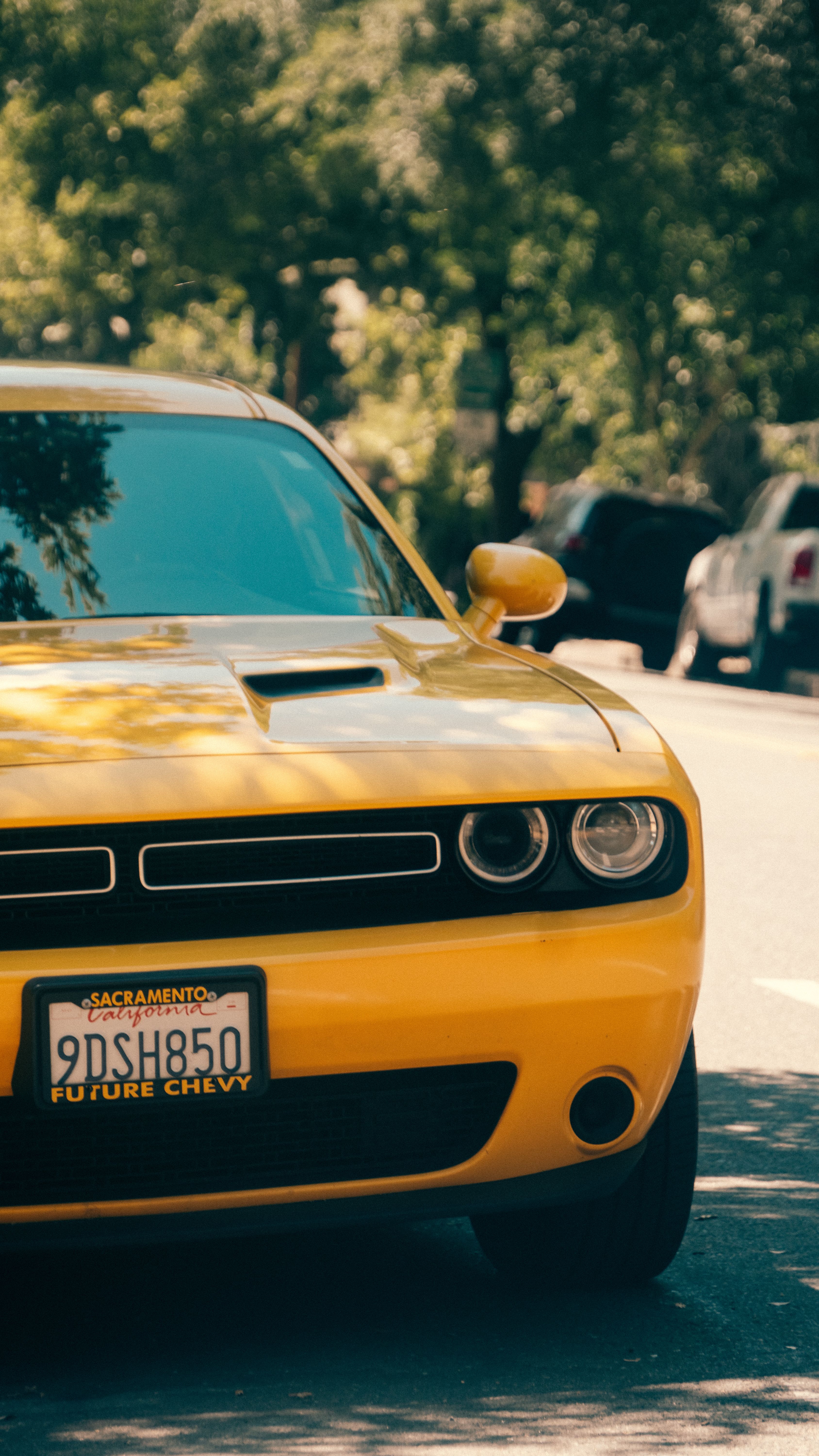 Voiture De Sport Jaune Garée Dans Une Rue Bordée D'arbres · Photo gratuite